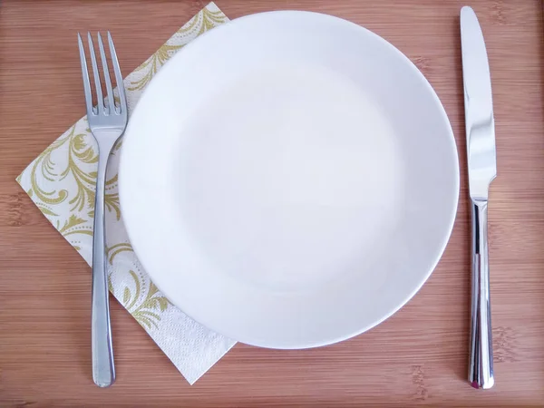 fork knife plate on wooden background