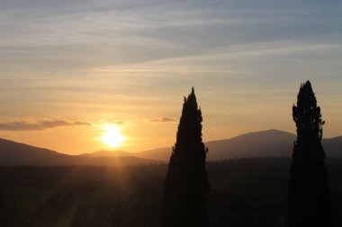 Toskana tepelerinde gün batımı Selvi siluetiyle