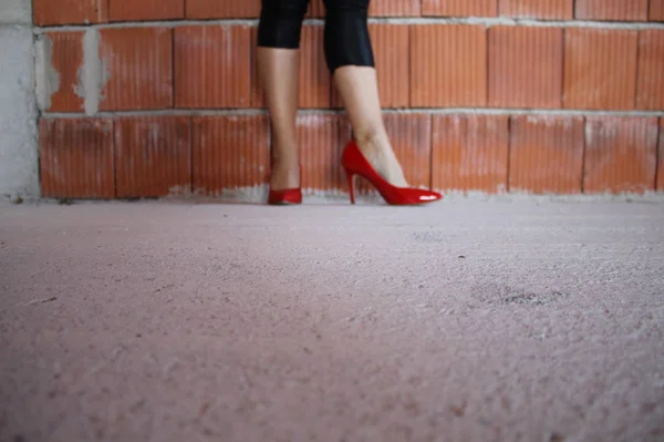 Γυναικεία Πόδια Κόκκινα Παπούτσια Φτέρνα Ένα Ημιτελές Σπίτι — Φωτογραφία Αρχείου