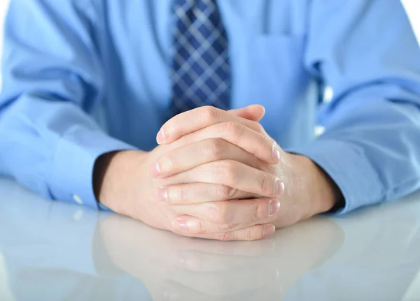 Zakenman met gekruiste handen rustend op tafel — Stockfoto