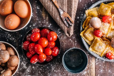 Eski ahşap bir masada mantar soslu ev yapımı ravioli yapmak için gerekli malzemeler. İtalyan vejetaryen yemeği. Kopyalama alanı