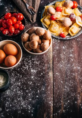 Eski ahşap bir masada mantar soslu ev yapımı ravioli yapmak için gerekli malzemeler. İtalyan vejetaryen yemeği. Kopyalama alanı