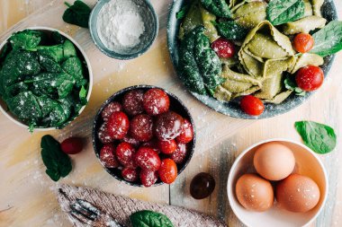Tahta tahtalarda ev yapımı ıspanaklı tortellini yapmak için ıspanak Tortellini malzemeleri. Boşluğu kopyala