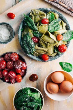 Tahta tahtalarda ev yapımı ıspanaklı tortellini yapmak için ıspanak Tortellini malzemeleri. Boşluğu kopyala