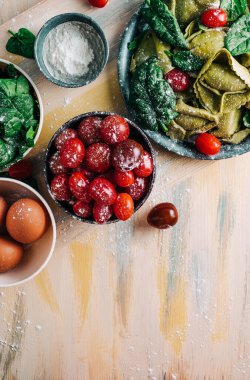 Tahta tahtalarda ev yapımı ıspanaklı tortellini yapmak için ıspanak Tortellini malzemeleri. Boşluğu kopyala