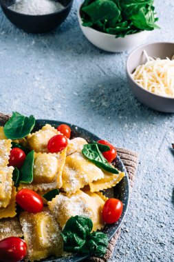 Tahta bir masada ıspanakla doldurulmuş taze ravioli makarnası. Ev yapımı İtalyan yemekleri.