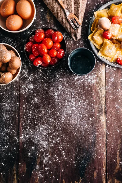 Eski ahşap bir masada mantar soslu ev yapımı ravioli yapmak için gerekli malzemeler. İtalyan vejetaryen yemeği. Kopyalama alanı