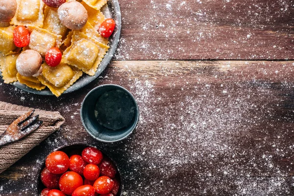 Eski ahşap bir masada mantar soslu ev yapımı ravioli yapmak için gerekli malzemeler. İtalyan vejetaryen yemeği. Kopyalama alanı