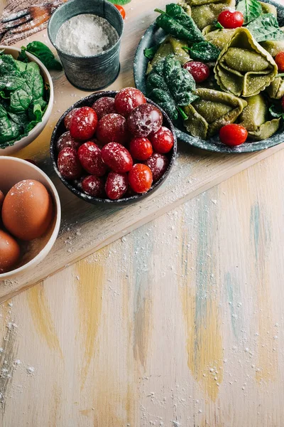 Tahta tahtalarda ev yapımı ıspanaklı tortellini yapmak için ıspanak Tortellini malzemeleri. Boşluğu kopyala