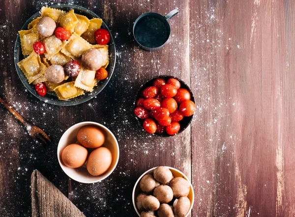 Eski ahşap bir masada mantar soslu ev yapımı ravioli yapmak için gerekli malzemeler. İtalyan vejetaryen yemeği. Kopyalama alanı