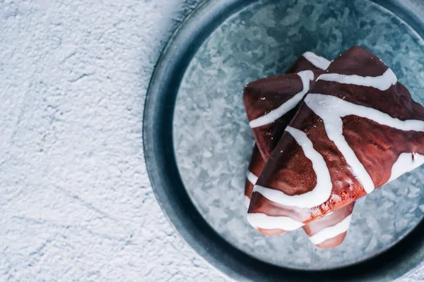 Sütlü siyah beyaz çikolatalı nefis ev yapımı tatlı. Tahta masada üçgen şekilli tatlı.