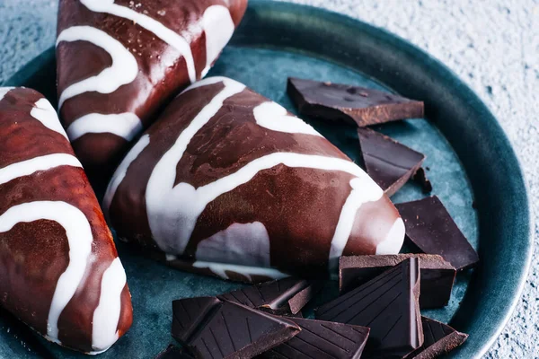 Sütlü siyah beyaz çikolatalı nefis ev yapımı tatlı. Tahta masada üçgen şekilli tatlı.