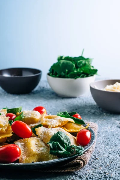 Tahta bir masada ıspanakla doldurulmuş taze ravioli makarnası. Ev yapımı İtalyan yemekleri.
