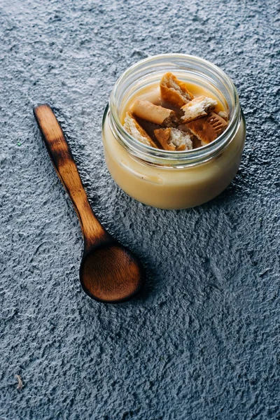 Mavi ahşap arka planda lezzetli vanilyalı puding.