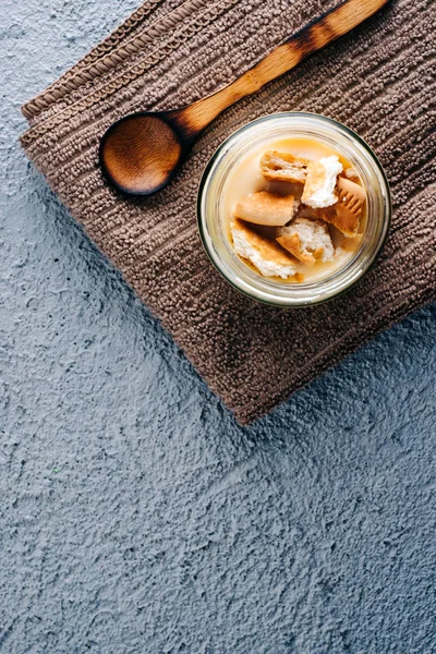 Mavi ahşap arka planda lezzetli vanilyalı puding.