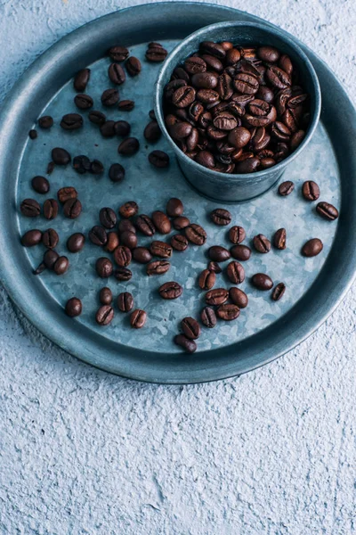 Coffee beans in metallic glass with blue background. concept power