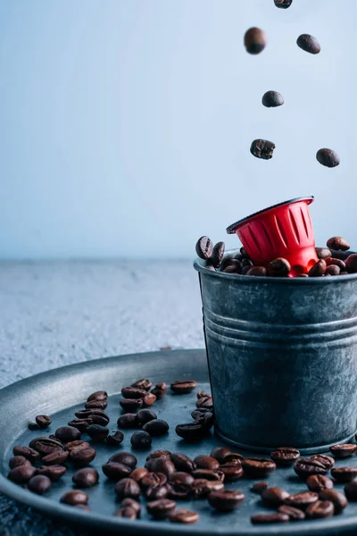 Kahve çekirdekli kahve kapsülü mavi arka planda. Uzayı kopyala Kahve konsepti