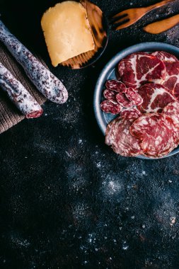 Klasik ahşap masadaki tipik İspanya peyniri ve sosisi çeşitleri. Koyun peyniri, fuet, sosis, sucuk. İspanyol yemeği. Metin için boş alan. Üst görünüm.