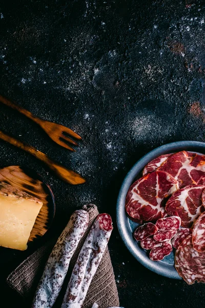 Klasik ahşap masadaki tipik İspanya peyniri ve sosisi çeşitleri. Koyun peyniri, fuet, sosis, sucuk. İspanyol yemeği. Metin için boş alan. Üst görünüm.