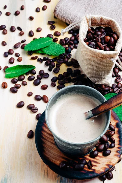Eski ahşap masada kahve fincanı ve dağınık kahve çekirdeği. Üst Manzara. Mesaj için yer var. Kopyalama alanı