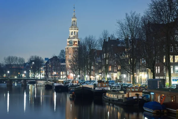 Embankment em Amsterdã com a igreja na luz azul da noite, os Países Baixos — Fotografia de Stock