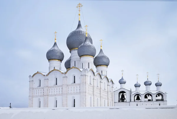 Uitzicht op de kathedraal van de veronderstelling en de klokkentoren achter de muur van het Kremlin van Rostov in de winter. — Stockfoto