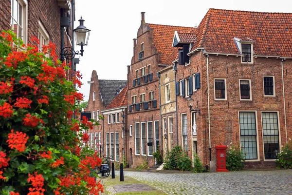 Red mailbox and red geranium on one of the central streets of Deventer, The Netherlands