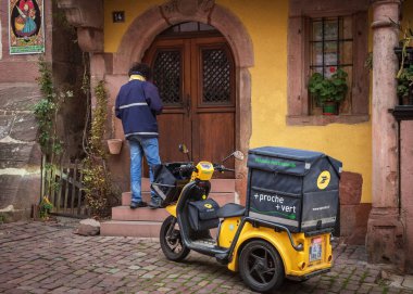 Riquewihr, Haut - Rhin / Fransa - 11 Kasım 2017: postacı posta elektrikli scooter köylülere sürdürmektedir