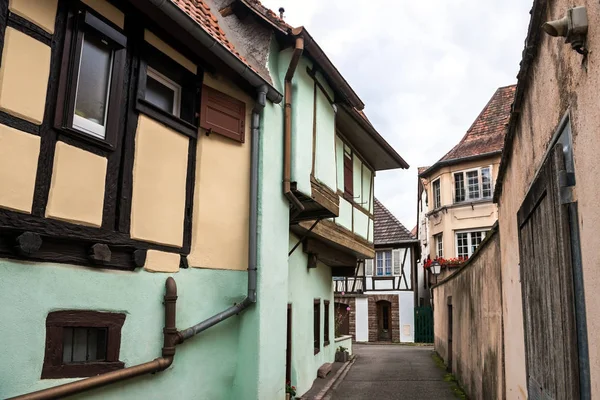 Strada laterale stretta con case a graticcio nello storico villaggio alsaziano di Ribeauville, Francia — Foto Stock