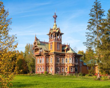 Astashovo, Kostroma Bölgesi / Rusya - 9 Eylül 2019: Güz ağaçlarıyla çevrili güzel restore edilmiş eski ahşap ev