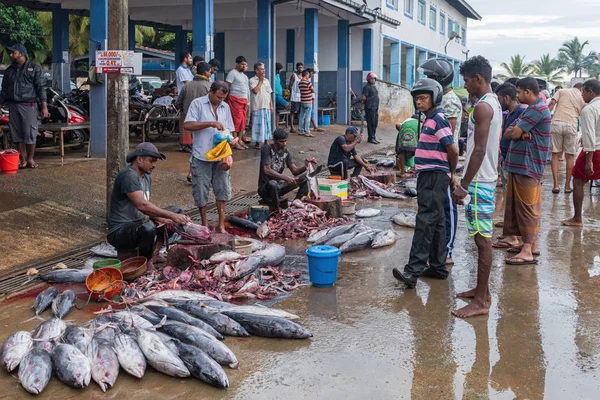 MIRISSA, SOUTHERN PROVINCE / SRI LANKA - NOVEMBRO 30, 2019: A população local no mercado de peixes está esperando que o peixe seja limpo e cortado em pedaços — Fotografia de Stock