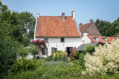 THORN, LIMBURG / The NETHERLANDS - 7 Haziran 2018: Turuncu kiremit çatılı beyaz evin etrafındaki güzel bahçe