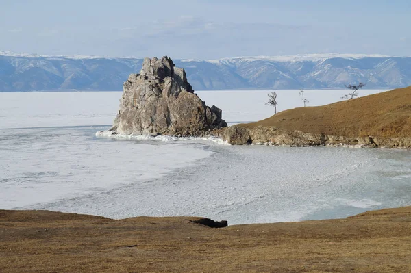 Прекрасный Вид Скалистую Скалу Поднимающуюся Замёрзшего Озера Фоне Горного Хребта — стоковое фото
