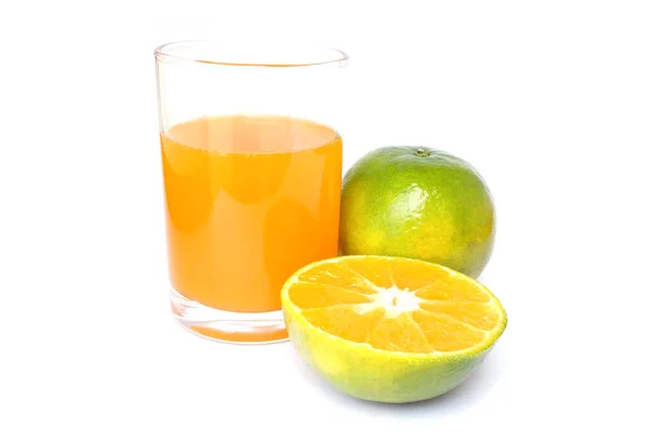 100% свіжого апельсинового соку в склянці з зеленими апельсинами і скибочками — стокове фото