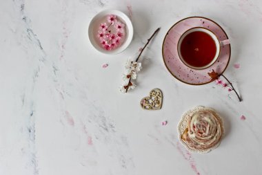 Tarçınlı rulo, çay ve çiçekli filizler beyaz arka planda