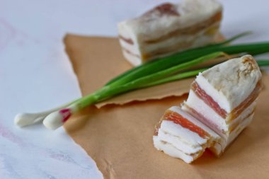 Sarımsaklı salo ve kağıt üzerinde yeşil soğan.