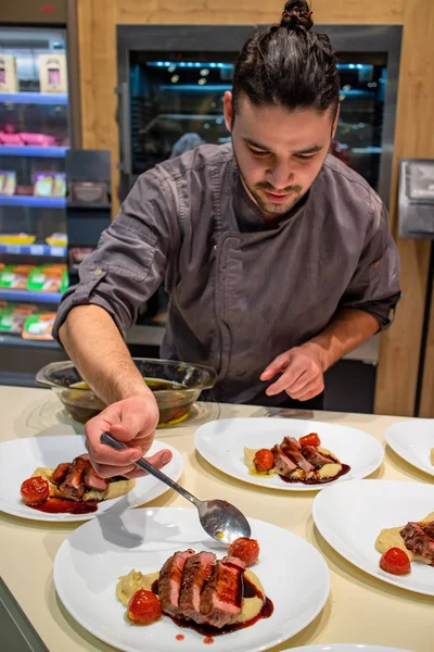 Şef, konuklara ikram etmeden önce kremalı kereviz püresi ve kırmızı şarap azaltma soslu kuru pirzola bifteği hazırlıyor. Seçici odaklanma. Restoran ve güzel yemek konsepti.