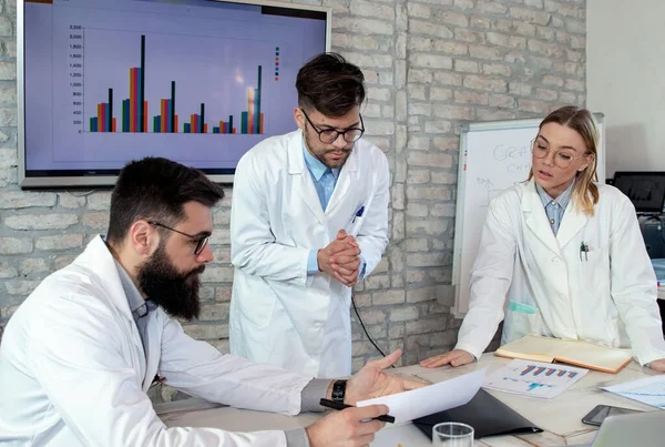 Doctors and medical researchers on conference meeting, discussing possible solutions for resolving a world health crisis. Health and medical concept. Selective focus.