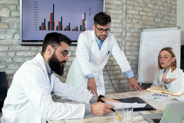 Doctors and medical researchers on conference meeting, discussing possible solutions for resolving a world health crisis. Health and medical concept. Selective focus.