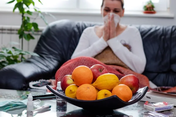 Žena Sedící Pohovce Před Miskou Čerstvého Ovoce Vysmrkající Hedvábného Papíru — Stock fotografie