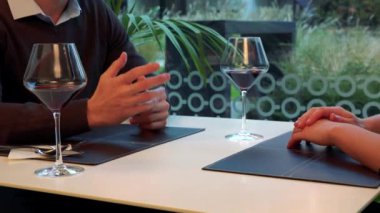 Bir restoranda bir masada bir görüşme sırasında erkek ve dişi eller gesticulate