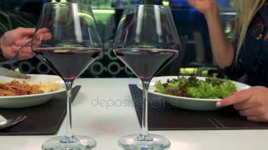 Bir erkek ve bir kadın bir Restoran, iki bardak şarap ön planda bir masada yemek