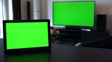 Bir tablet üzerinde yatay bir konumda - bir Tv arka planda bir Resepsiyon her ikisi de yeşil ekranlar var