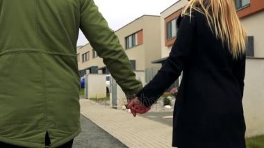 Bir çift arkadan ellerini tutar ve sokakta yürüyor