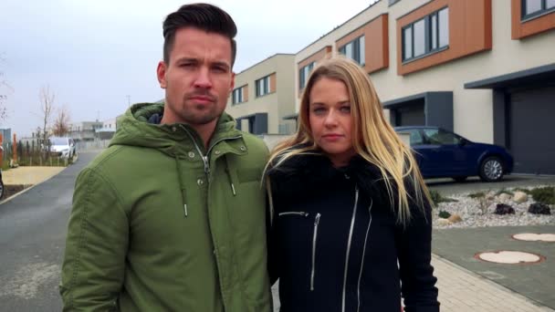 Ein junges, attraktives Paar steht auf einer Straße in einer Nachbarschaft und schüttelt den Kopf — Stockvideo