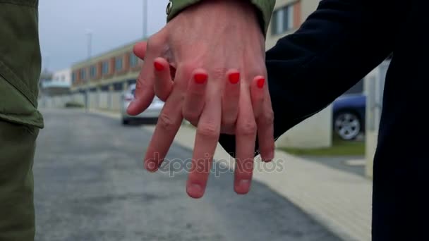 Руки (один мужчина, одна женщина) соединяются, улица на заднем плане — стоковое видео