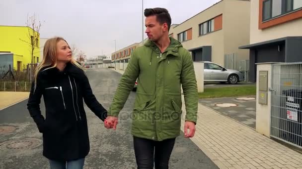 Ein junges, attraktives Paar geht eine Straße entlang und spricht — Stockvideo