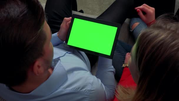 Мужчина держит планшет с зеленым экраном, объясняет женщина — стоковое видео