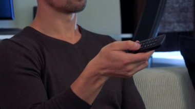 Bir adam bir koltukta oturur ve bir denetleyicisi ile Tıklanma