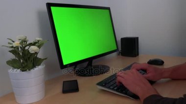 Yeşil bir ekran ile bir PC yazarak eller